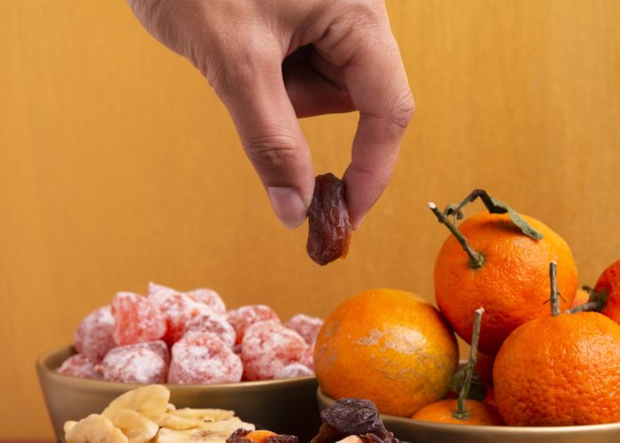 close-up-hand-holding-dehydrated-fruit-chinese-new-year